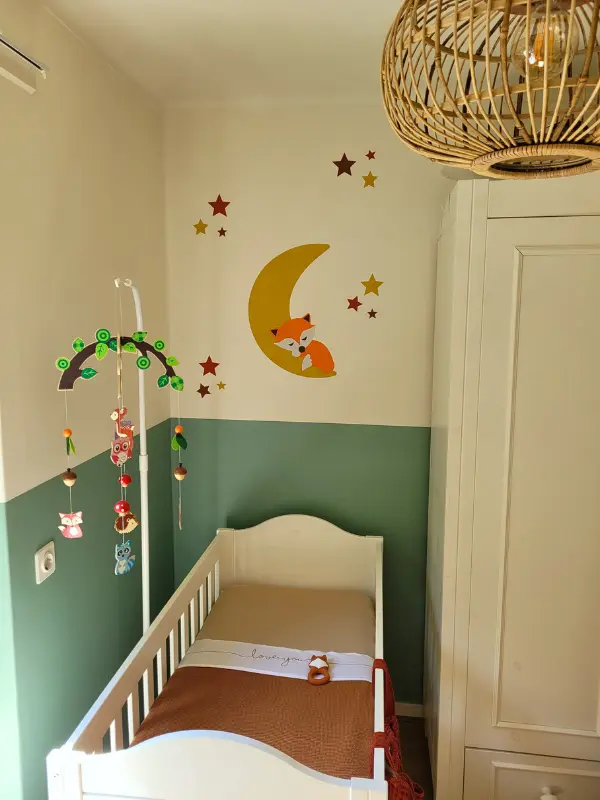 Mintgroene babykamer met okergele maan en sterren behangsticker met slapend vosje.